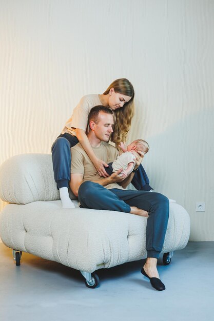 Happy mother and father hugging their newborn baby Parents and a smiling child in their arms A young family with a newborn baby