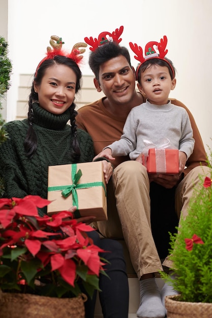 Happy mother father and little son wearing reindeer antlers headbands for christmas party