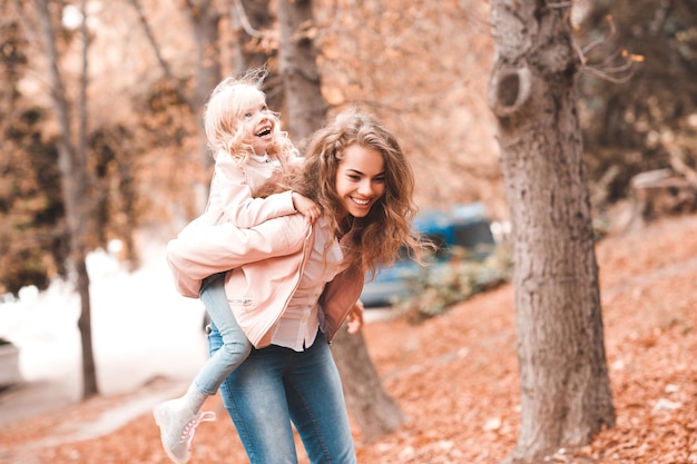 Happy mother having fun with baby daughter in park