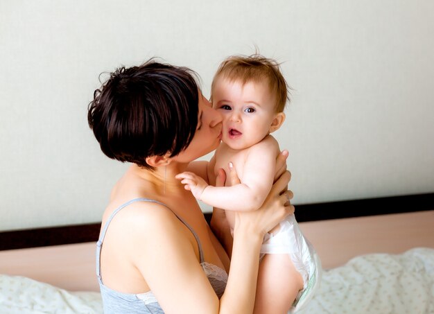 Happy mother holding her baby.mom kisses her baby