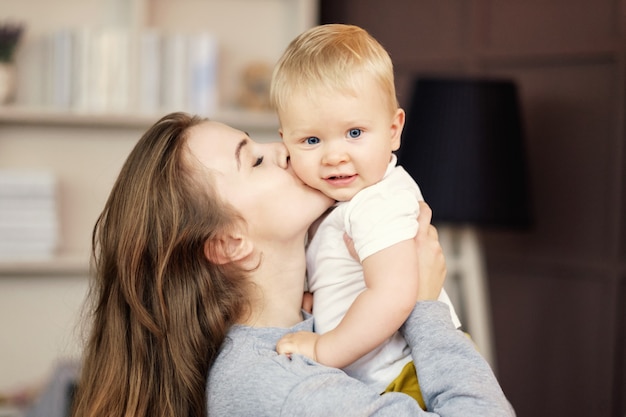 幸せな母が自宅で息子を抱擁し、キス、感情、母と子の関係、