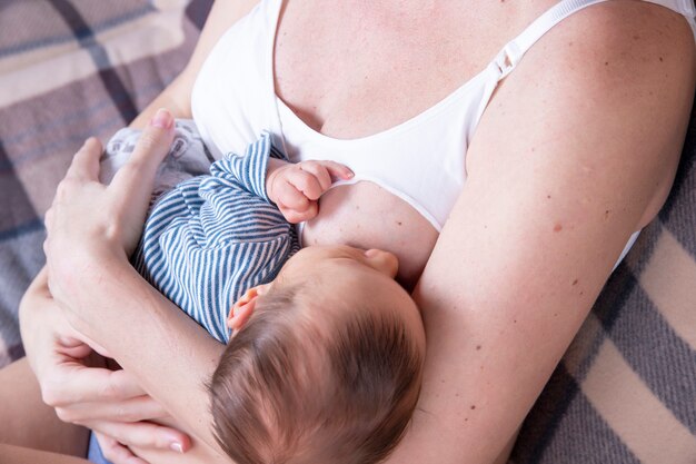 Happy mother is breastfeeding her newborn baby.