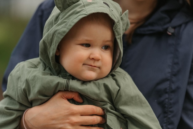 Una madre felice tiene in braccio la sua giovane figlia in una giornata nuvolosa