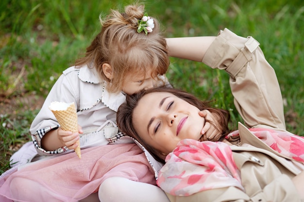 행복 한 엄마와 작은 딸 야외. 엄마와 그녀의 아이는 녹색 공원에서 함께 자연을 즐기고 키스와 포옹.