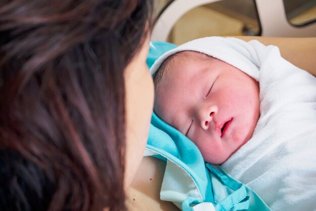 病院での分娩後の幸せな母親と新生児