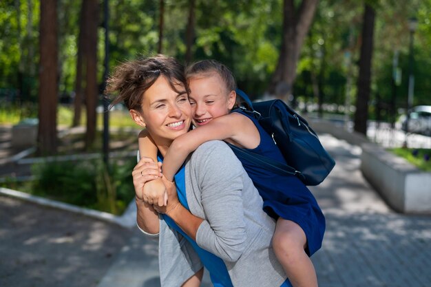 Foto una madre felice che porta su di sé la figlia