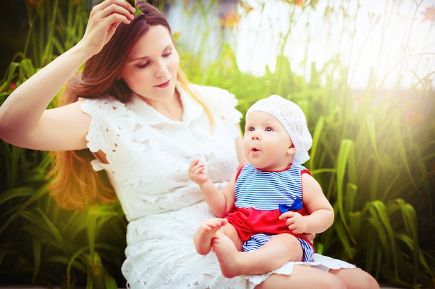 Happy mother playing with child in summer park