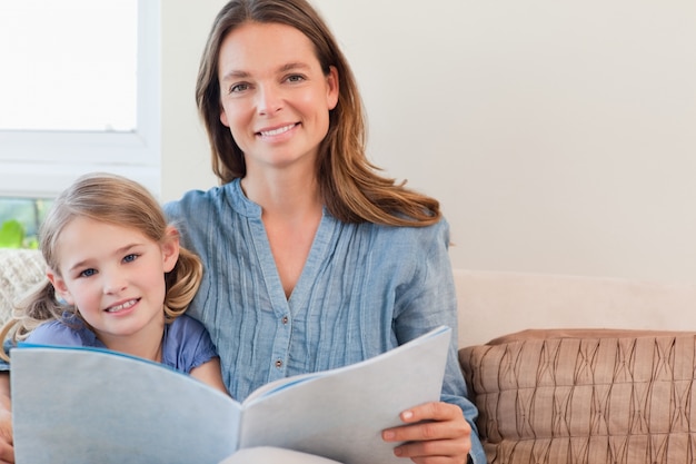 Happy mother reading a book to her daughter