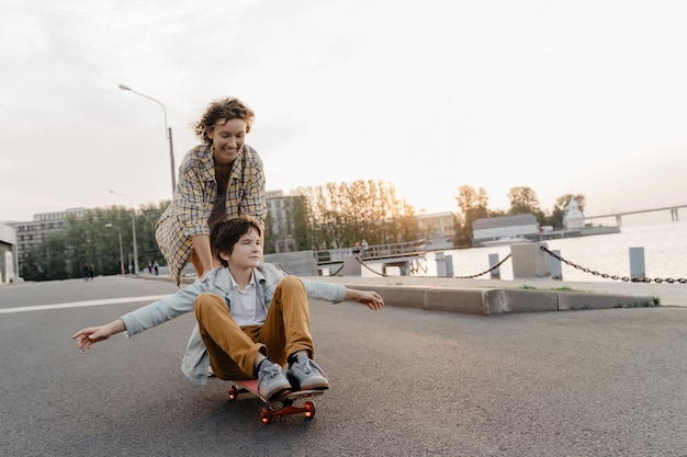 Фото Счастливая мать катает сына на скейтборде