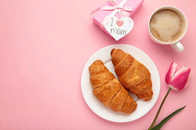 幸せな母の日 一杯のコーヒーと美しい朝食ランチ 焼きたてのクロワッサン チューリップとギフト 春の休日の家族関係