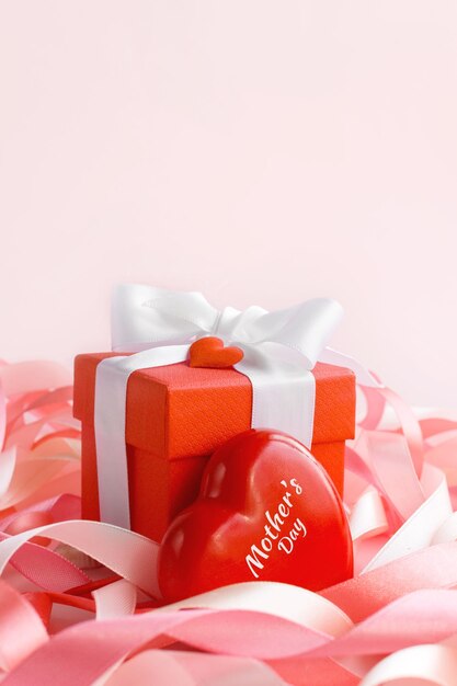 Happy Mother's Day or Happy women's day Red box with a gift in festive ribbons and heart