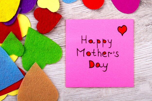 Happy Mother's Day note. Greeting paper and colorful hearts. Mother deserves pure love. Celebrate your holidays brightly.