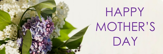 Happy mother's day text sign greeting card spring flat lay purple lilac flowers on white background flat lay blooming flowers in light web banner