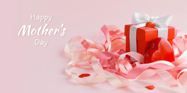 幸せな母の日または女性の日お祝いのリボンとピンクの背景に白いグリーティングカード