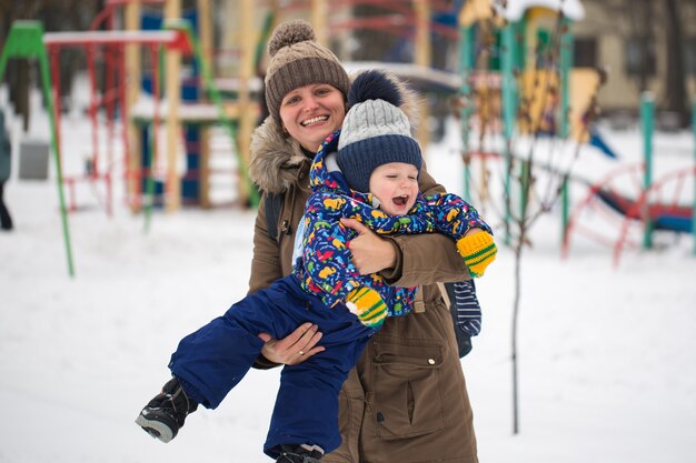 Happy mother and small boy in the winter snow