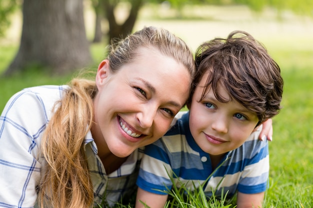 Happy mother and son lying in park