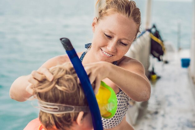 Happy mother and son snorkeling at the ship