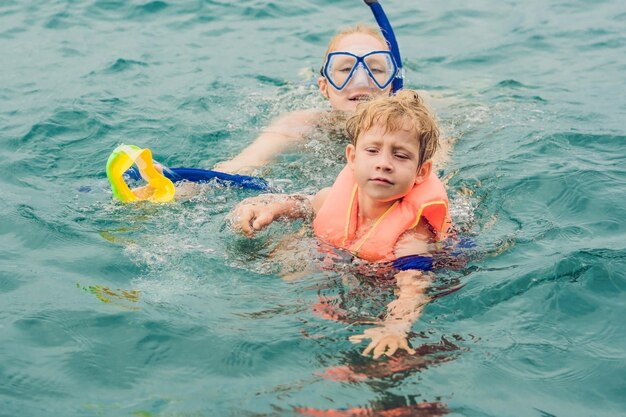 Happy mother and son snorkeling at the ship