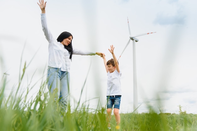 Happy mother and son at the wind turbine farm