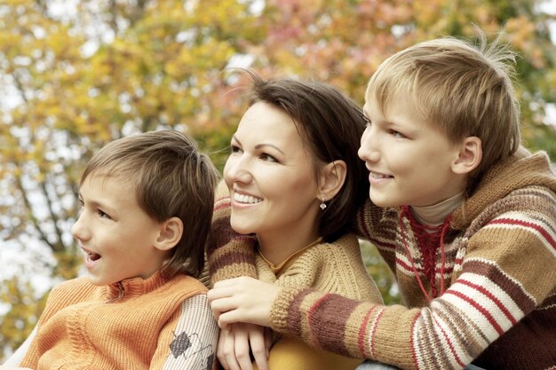 Happy Mother and sons in the autumn park