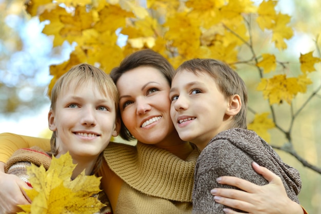 Happy Mother and sons in the autumn park