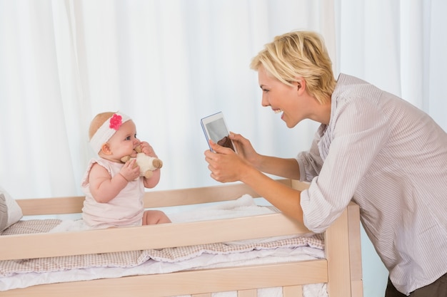 Happy mother taking a picture of her baby girl 