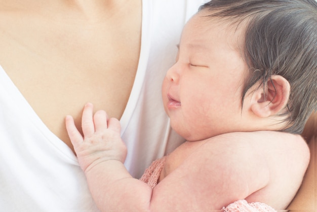 happy mother with baby in bed