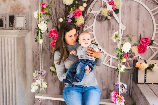 Happy mother with baby boy in the room.