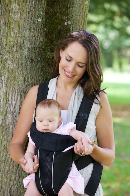 Happy mother with baby in sling