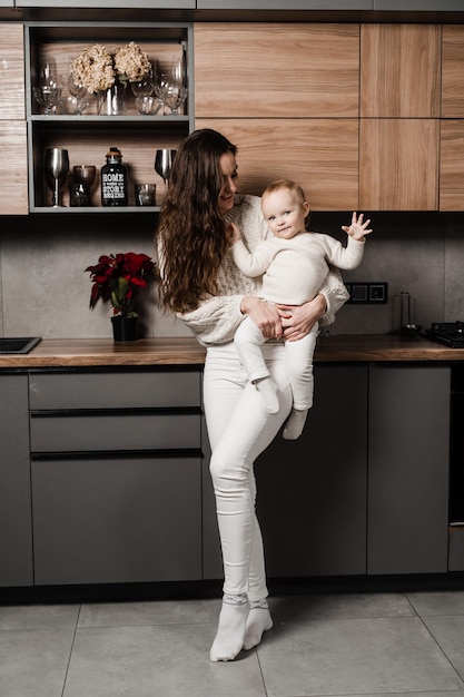 台所で娘と一緒に幸せな母 月と彼女の子供は家で一緒に時間を過ごす