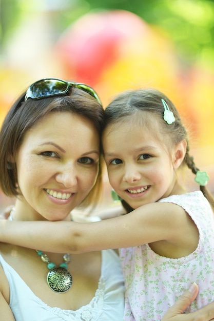 Happy mother with her daughter walk in summer park