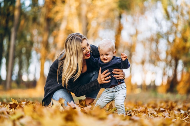 Happy mother with her little baby son have fun in the city park