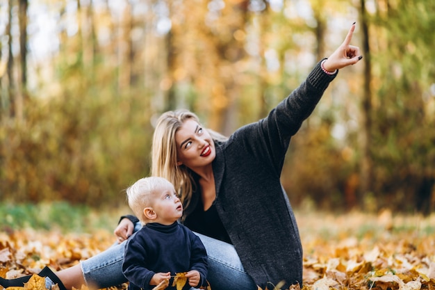 Happy mother with her little baby son have fun in the city park