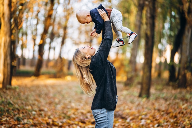 Happy mother with her little baby son have fun in the city park