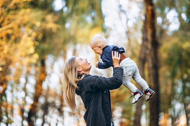 Happy mother with her little baby son have fun in the city park