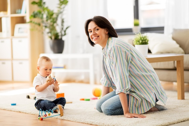 happy mother with little baby son playing at home