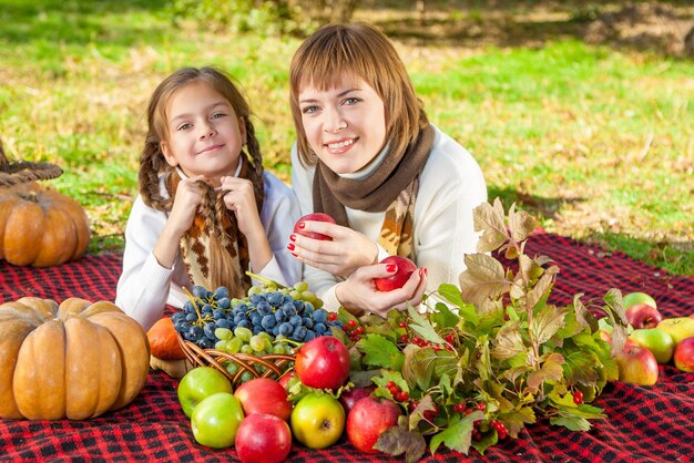 Happy mother with little daughter in autumn park