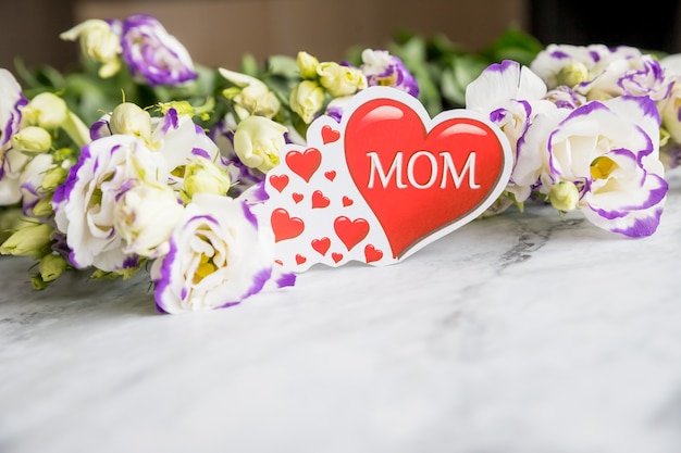 Photo happy mothers day concept eustoma flowers bouquet with red heart on old marble desk. copy space