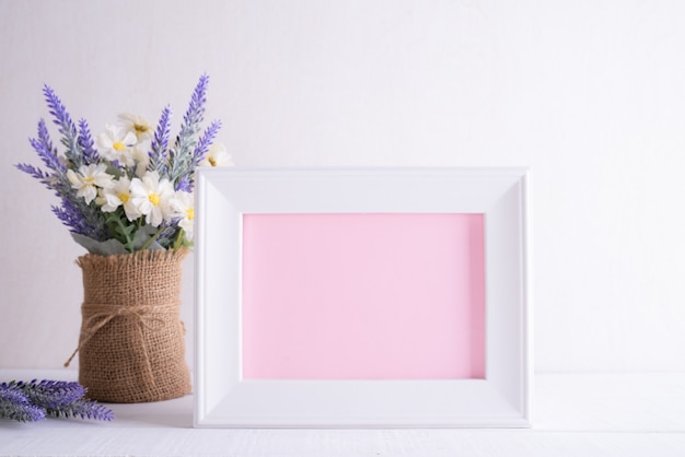 Happy mothers day concept. White picture frame with lovely purple flower 