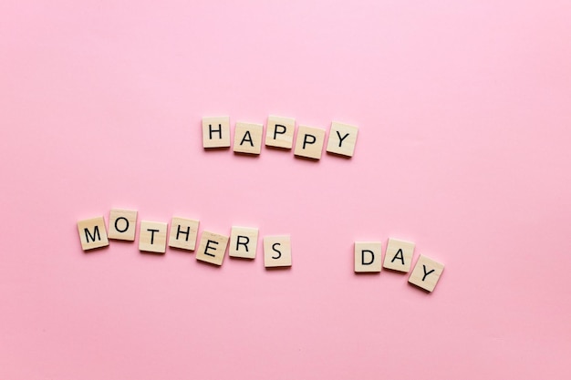 Happy Mothers Day gemaakt van houten letters op een roze achtergrond Moederdag kaart