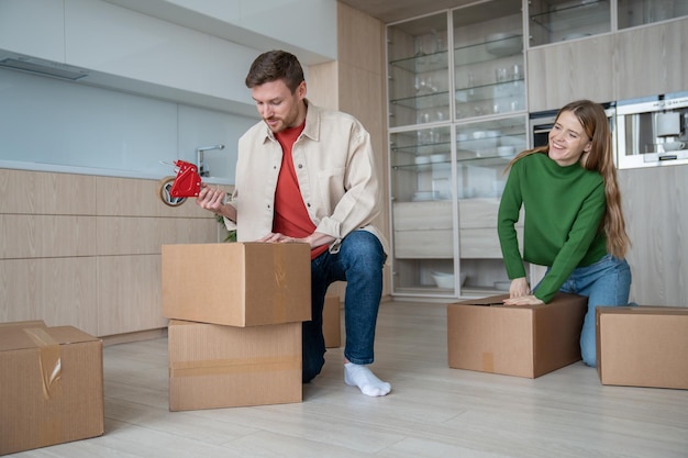Photo happy move into newlyweds own apartment packing things into cardboard boxes is pleasant routine