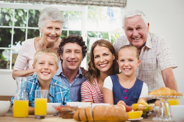 Photo happy multi-generation family by breakfast table
