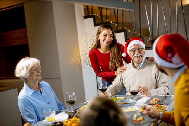 Happy multi generation family celebrating New Year by the table at home