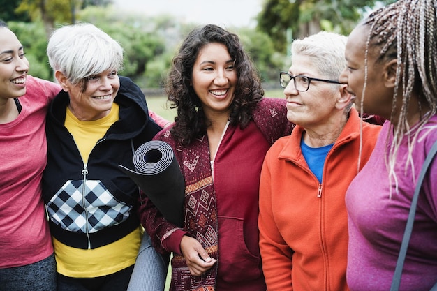 Donne multigenerazionali felici che si divertono insieme dopo l'allenamento sportivo all'aperto focus sul viso della ragazza centrale