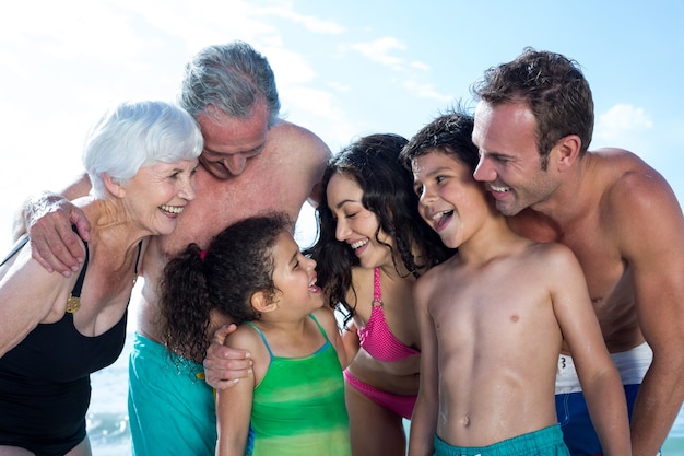 Famiglia felice multi genration in piedi in spiaggia