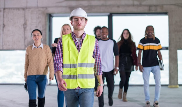 happy multiethnic business team walking through  unfinished startup office during moving in at new building