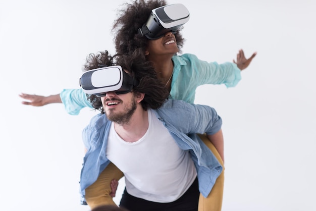 仮想現実、白い背景で隔離の VR ヘッドセット メガネを使用して経験を得る幸せな多民族のカップル