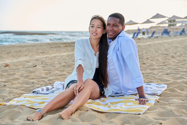 Счастливая многонациональная семья вместе отдыхает на пляже