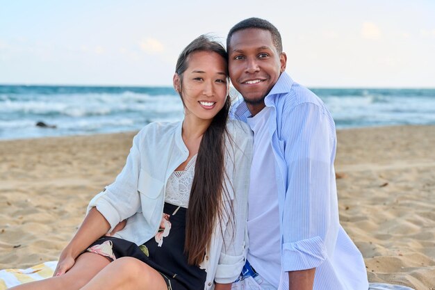 Happy multiethnic family having a rest on the beach together