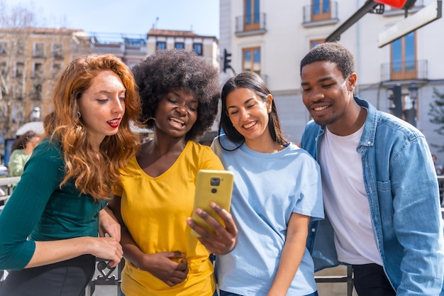 Felici amici multietnici che ridono facendo un selfie di gruppo sulla strada della città che ridono insieme all'aperto